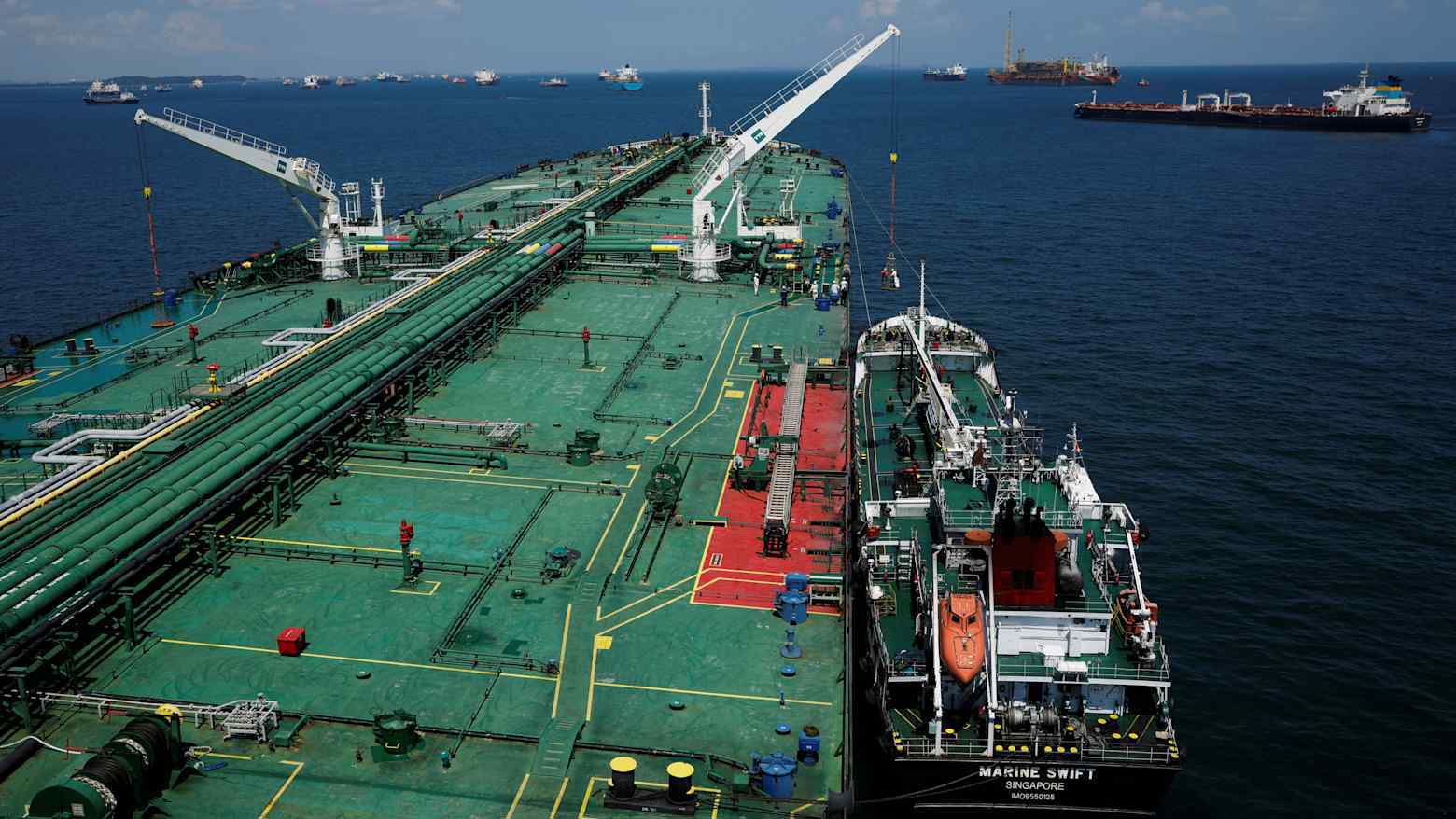 Một tàu chở nhiên liệu (bunker vessel) đang chuẩn bị tiếp nhiên liệu cho một tàu chở dầu (tanker) tại vùng biển ngoài khơi Singapore. Quốc đảo này hiện là trung tâm tiếp nhiên liệu lớn nhất thế giới. (Ảnh: Reuters) Một tàu chở nhiên liệu (bunker vessel) đang chuẩn bị tiếp nhiên liệu cho một tàu chở dầu (tanker) tại vùng biển ngoài khơi Singapore. Quốc đảo này hiện là trung tâm tiếp nhiên liệu lớn nhất thế giới. (Ảnh: Reuters)