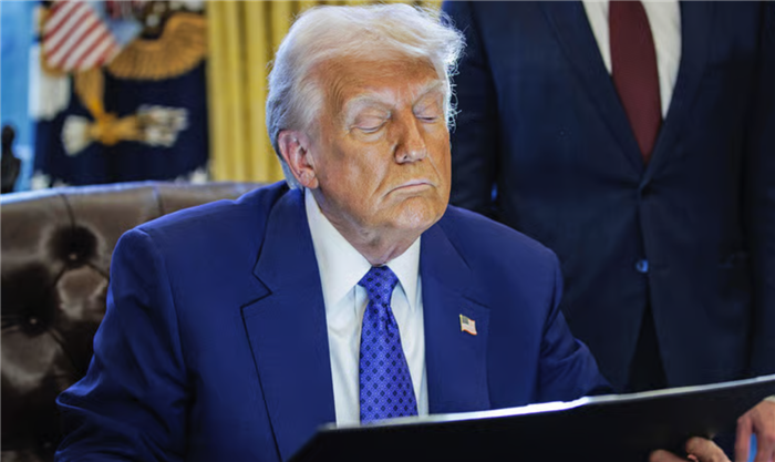 Ông Donald Trump chăm chú đọc một sắc lệnh trước khi ký ban hành (Nguồn: Picture Alliance)