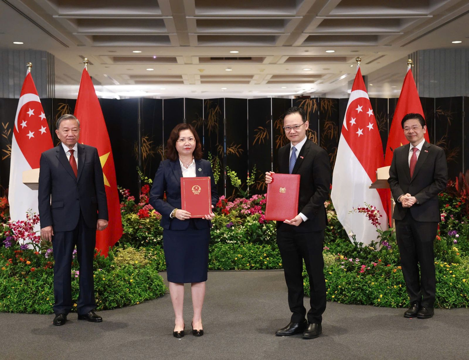 Tổng Bí thư Tô Lâm và Thủ tướng Singapore Lawrence Wong chứng kiến việc trao đổi Ý định thư hợp tác giữa bà Vũ Thị Chân Phương (Chủ tịch SSC) và ông Lim Tuang Lee (Phó tổng giám đốc Khối thị trường vốn MAS). Ảnh: SSC