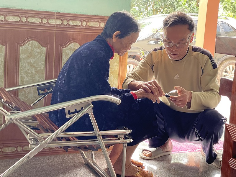 Cụ Trần Thị Duyên bên người con út Trần Hữu Sự, người cùng gia đình bền bỉ thực hiện tâm nguyện đưa liệt sĩ Trần Hữu Quân trở về quê hương